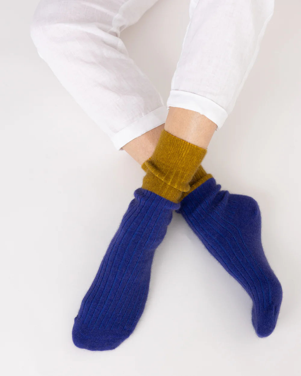 Possum merino stripe socks in royal blue and olive worn on feet