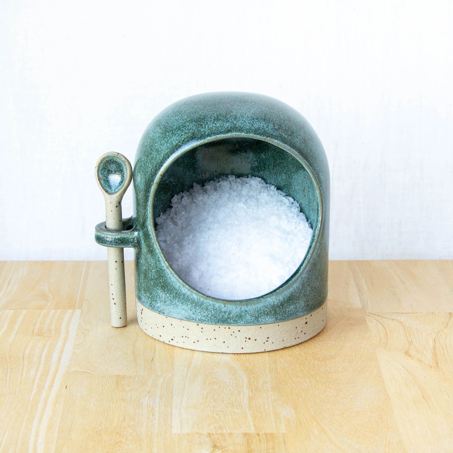 Handmade ceramic salt pig with spoon in lichen green glaze filled with salt