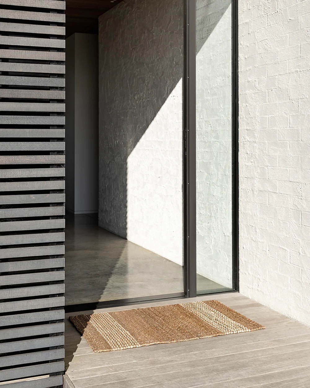 Natural jute entrance door mat at a modern home entrance