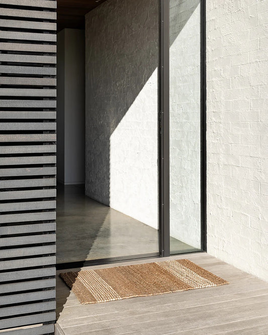 Natural jute entrance door mat at a modern home entrance